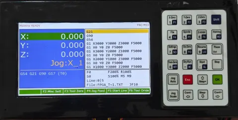TNC-M33 controller, front panel, powered on and running a job
